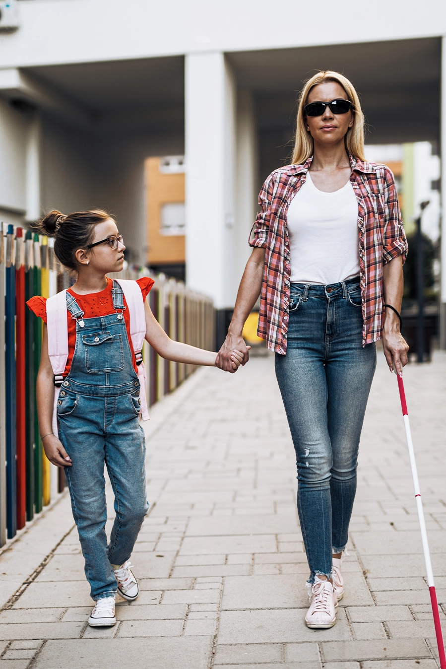 Lady with a red and white cane, signifying that she is both deaf and blind